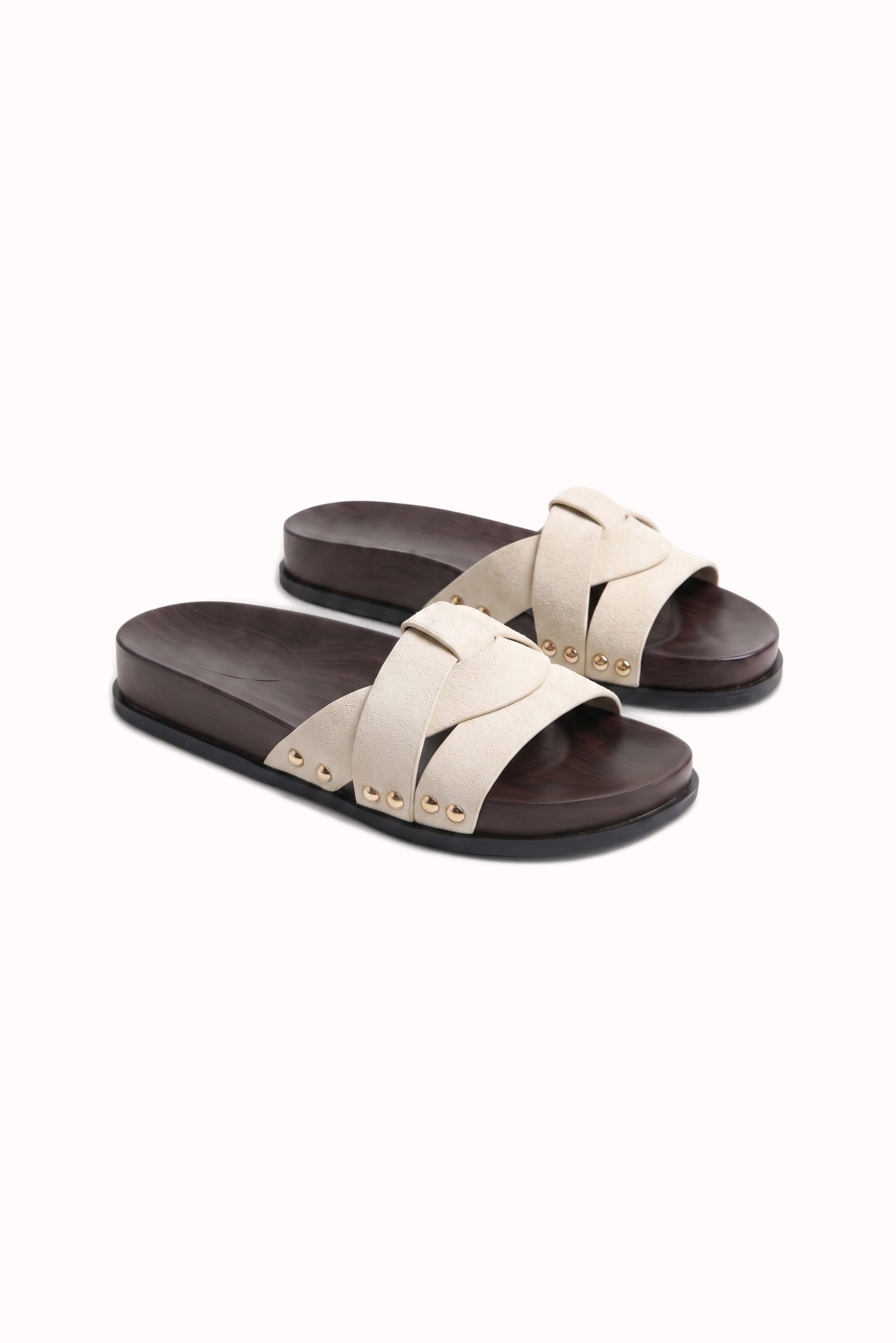 Mules plates à brides croisées et détails cloutés