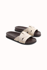 Mules plates à brides croisées et détails cloutés